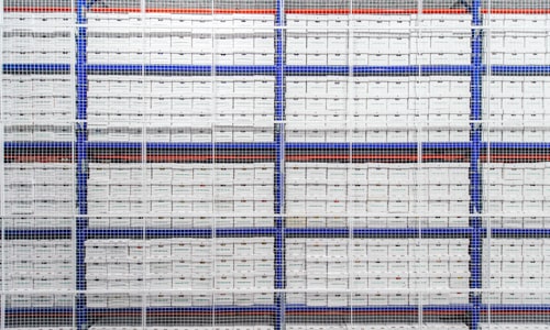 Un mur fait d'étagères remplies de boîtes d'archives Merak